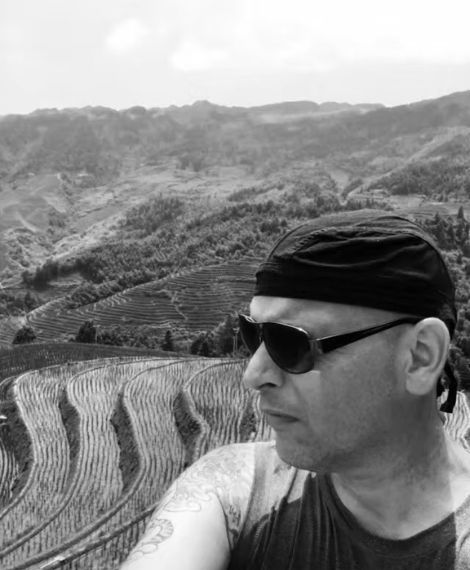 A black and white photo of Anton at the Longji Rice terrace in Guilin, China