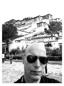Black and white photo of Anton in front of the Potala Palace in Lhasa, Tibet.