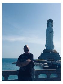 Colour photo of Anton by the Guanyin Buddha in Sanya, Hainan, China.